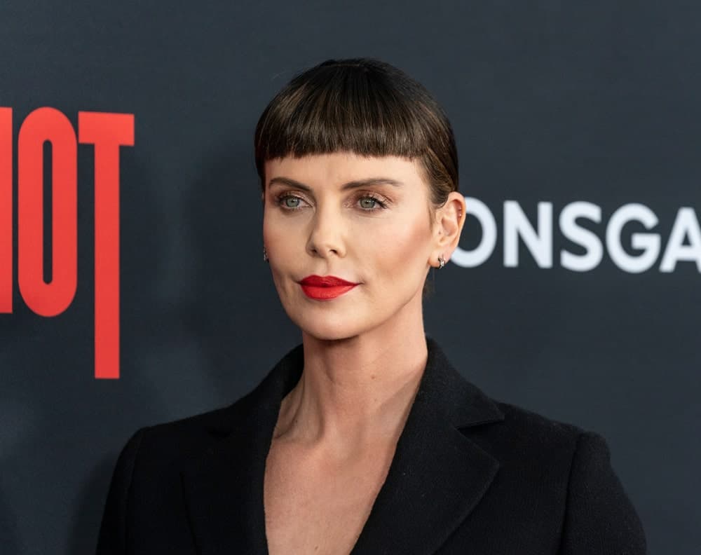 During the premiere of Long Shot at AMC Lincoln Center Theater on April 30, 2019, Charlize Theron flaunted a neat updo with short blunt bangs. She finished the look with a black suit and red lipstick.