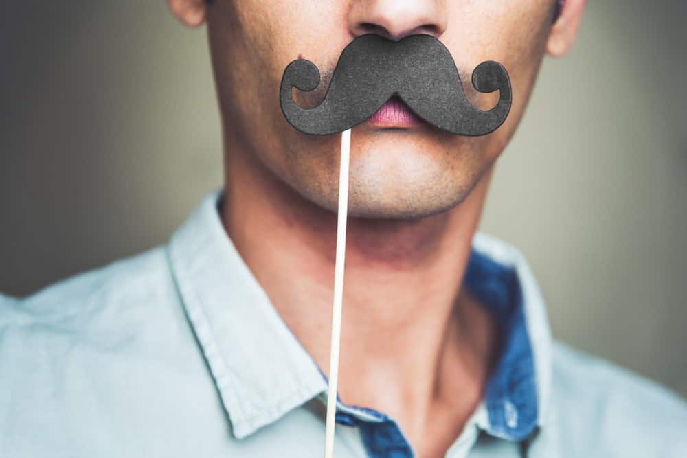 Man wearing a fake paper mustache.