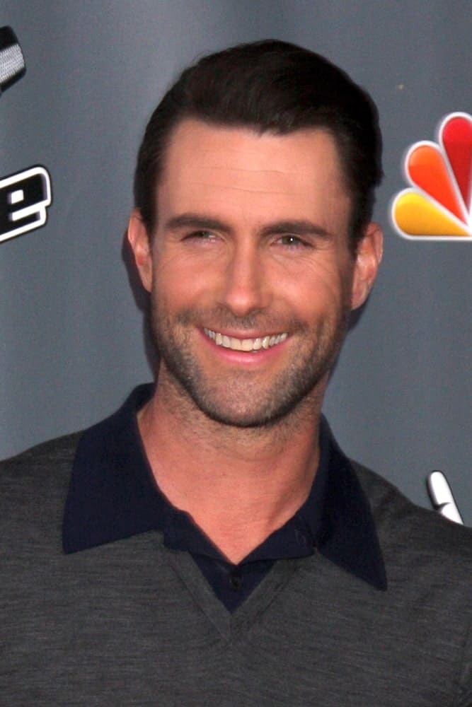 Adam Levine's brilliant smile flashed with his trimmed beard and brushed back hairstyle with a neat fade finish at the The Voice Season 5 Judges Photocall at Universal Studios Lot on November 7, 2013 in Los Angeles, CA.