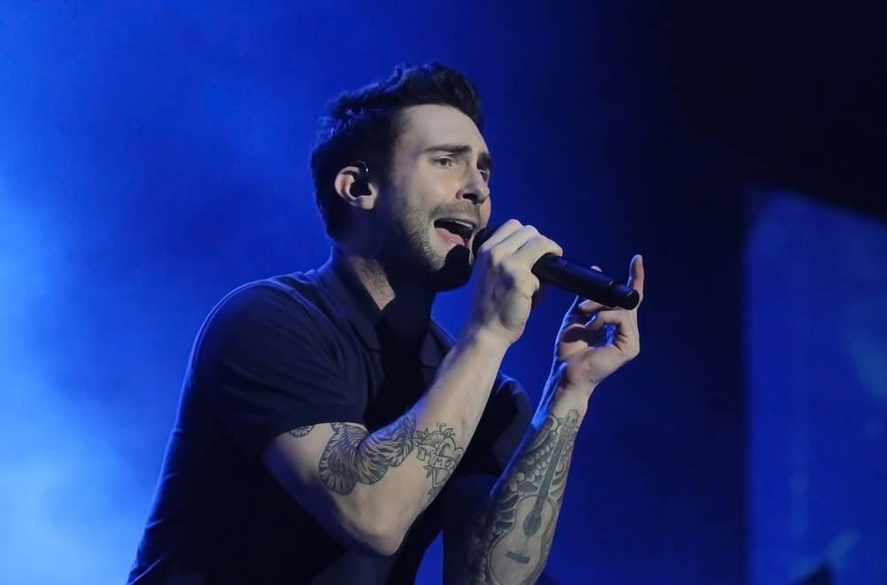 Singer Adam Levine from Maroon 5 rocked the stage of Rio de Janeiro on September 16, 2017 wearing a black collared shirt with his side-swept pompadour fade hairstyle and five o'clock shadow.