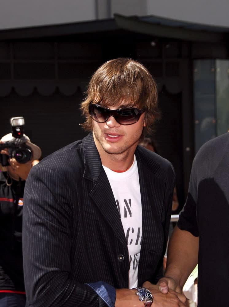 Ashton Kutcher was at the induction ceremony for Kevin Costner's hand and footprint ceremony in Hollywood, CA on September 06, 2006. His long and wavy hairstyle was dyed brown with a flippy finish at the side and bangs.