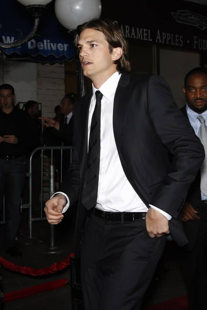 Ashton Kutcher balanced his classy black suit with a casual long highlighted hairstyle with a mullet at the premiere of 'No Strings Attached' at the Regency Village Theater in Los Angeles, CA on January 11, 2011.