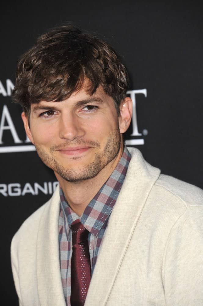 Ashton Kutcher had a short highlighted wavy fringe hairstyle at the Los Angeles premiere of his movie "Jobs" at the Regal Cinemas on August 13, 2013 in Los Angeles, CA.