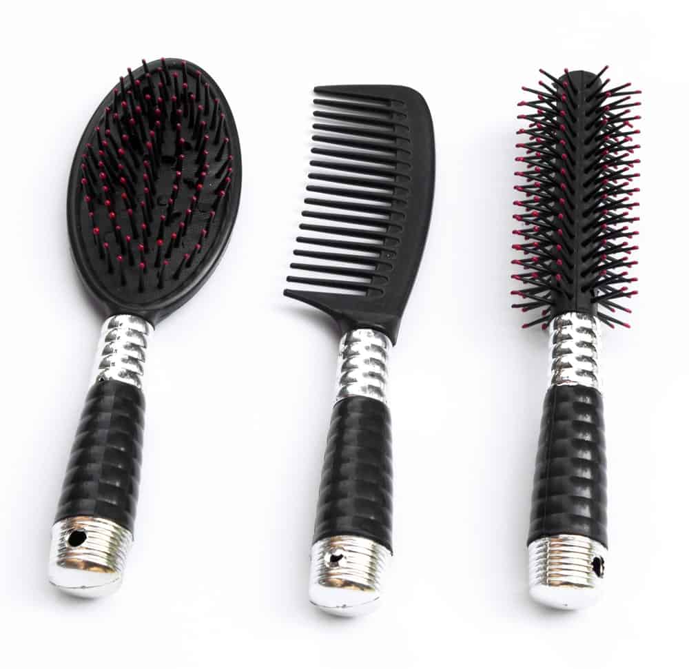 A focused look of a pair of hair brush and a comb on a white background.
