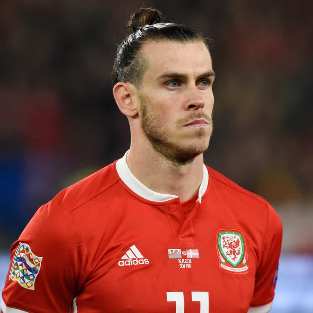 The speedy Midfielder of Real Madrid, Gareth Bale sporting his signature man bun hairstyle during a match between Wales national team where Bale plays and Denmark national football team.