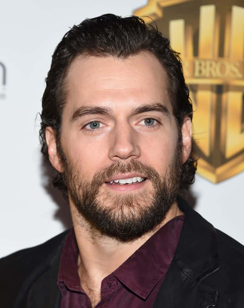Henry Cavill went with a full beard and longer hair arranged in a gelled sweep back during the CinemaCon 2017-Warner Brothers on March 29, 2017.