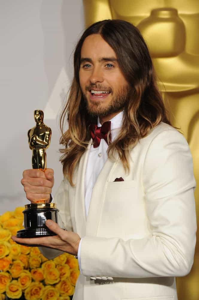 Jared Leto at the 86th Annual Academy Awards on March 2, 2014 sporting his long brunette locks styled with subtle waves and light highlights.