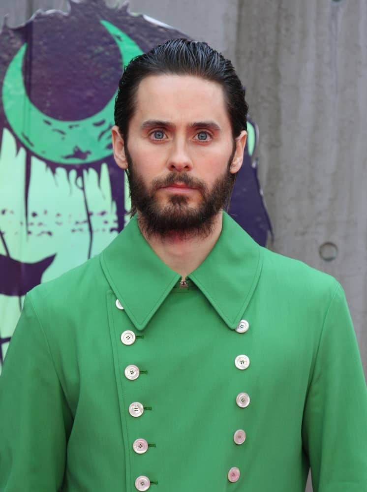 Jared Leto made an appearance at the Suicide Squad film premiere on August 3, 2016 wearing a green buttoned top and a dark slicked hairstyle accompanied with his stubble beard.