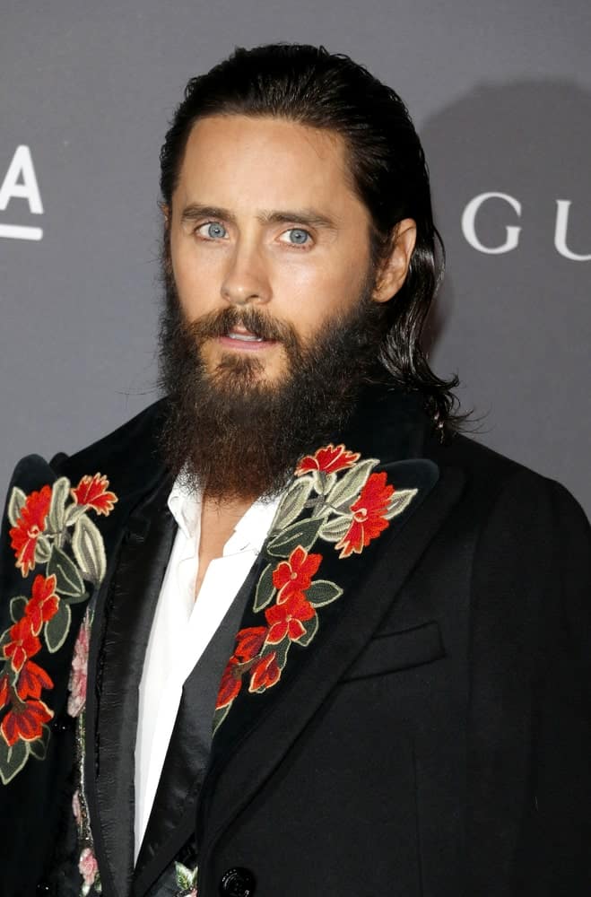 Jared Leto gelled his long black hair into a slicked back hairstyle for the 2017 LACMA Art + Film Gala held on November 4th. He complemented it with a black suit embroidered with floral patches.