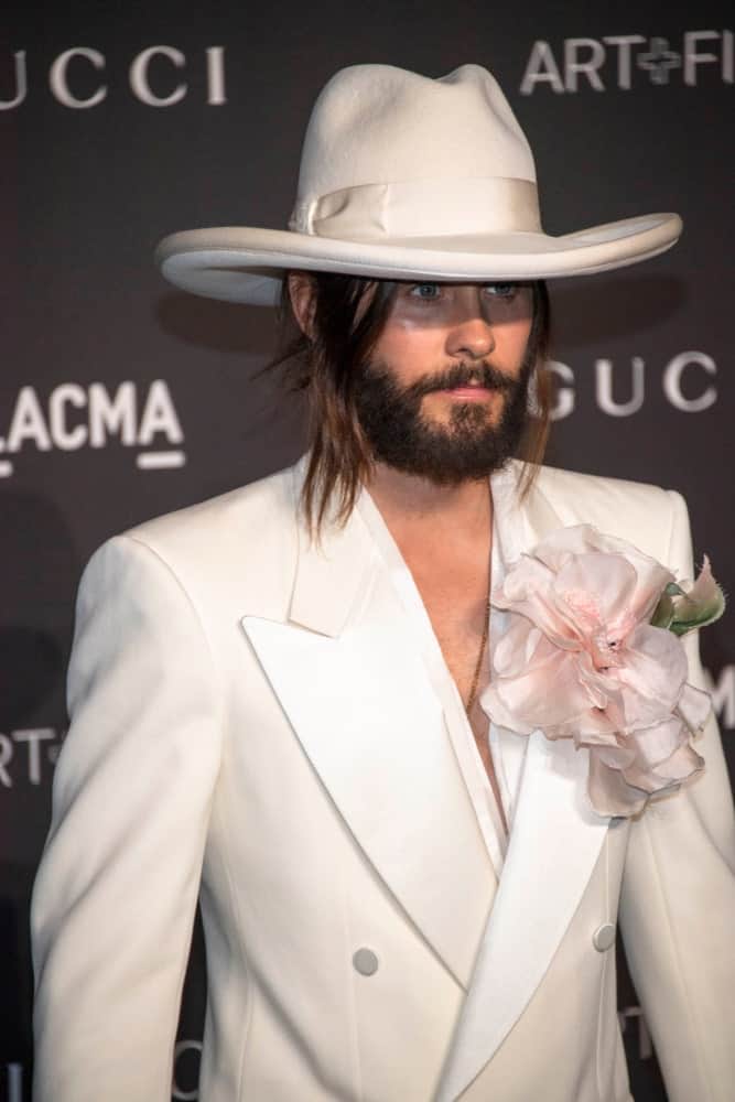 Jared Leto gathered his long locks into a man bun with side tendrils at the 2018 LACMA Art+Film Gala Honoring Catherine Opie + Guillermo Del Toro on November 3rd. He finished the look with a white suit and cowboy hat.