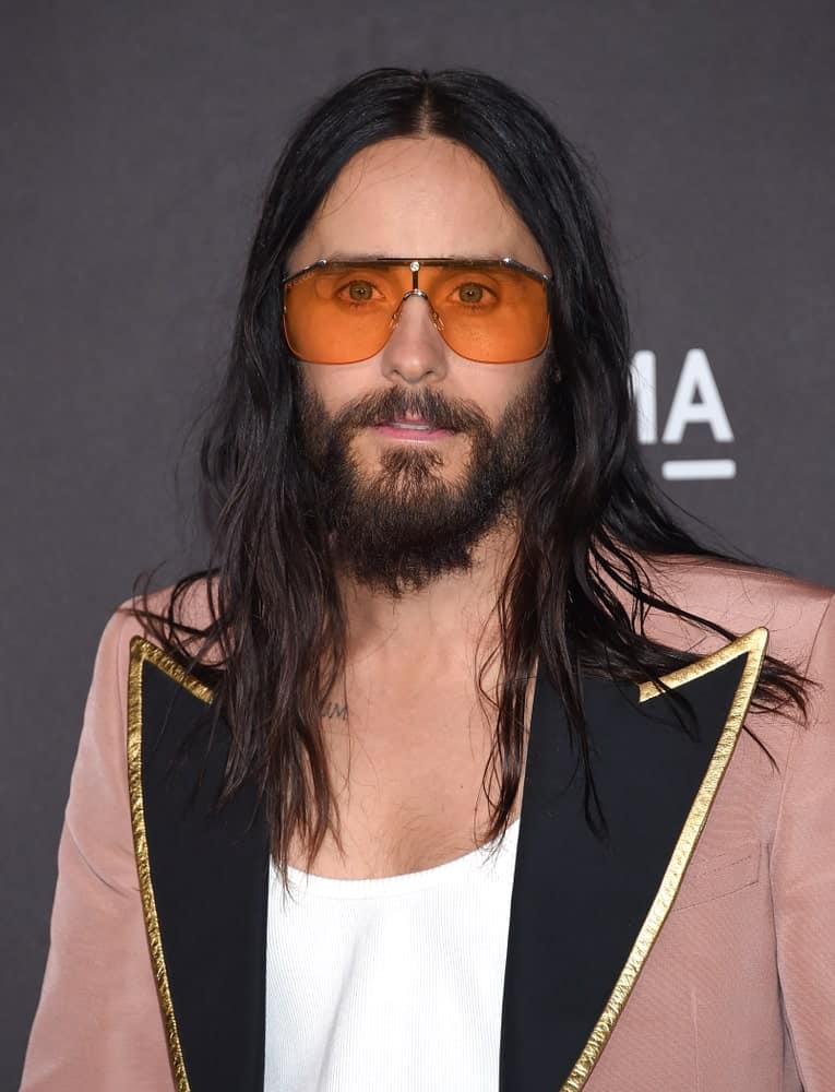 Jared Leto wore a long tousled hairstyle that's complemented with an edgy suit and orange shades at LACMA Art and Film Gala 2019 held on November 2nd.