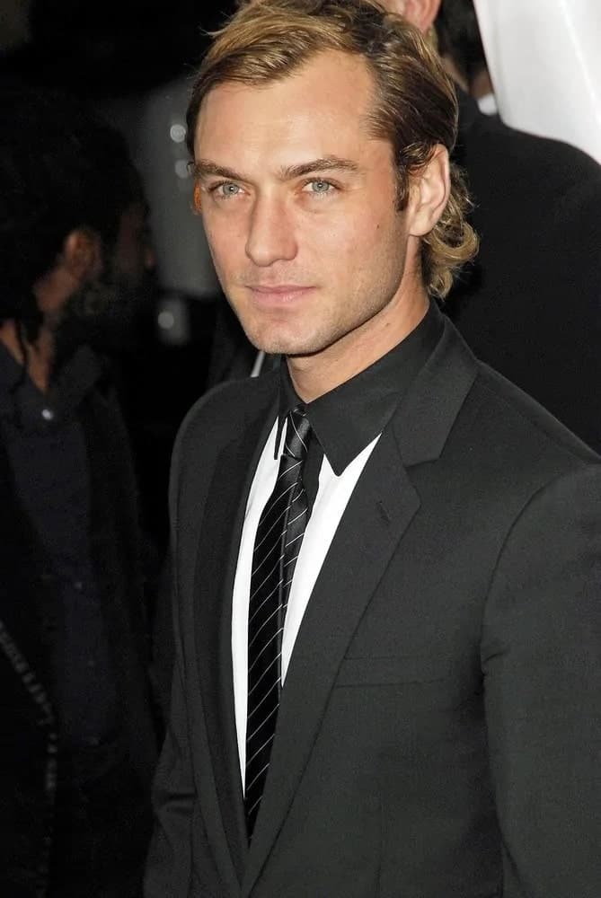 Actor Jude Law looked absolutely gorgeous with his medium-length side-parted hairstyle with some curls flipping at the tips of his hair when he attended the New York premiere of “The Holiday” in 2006.