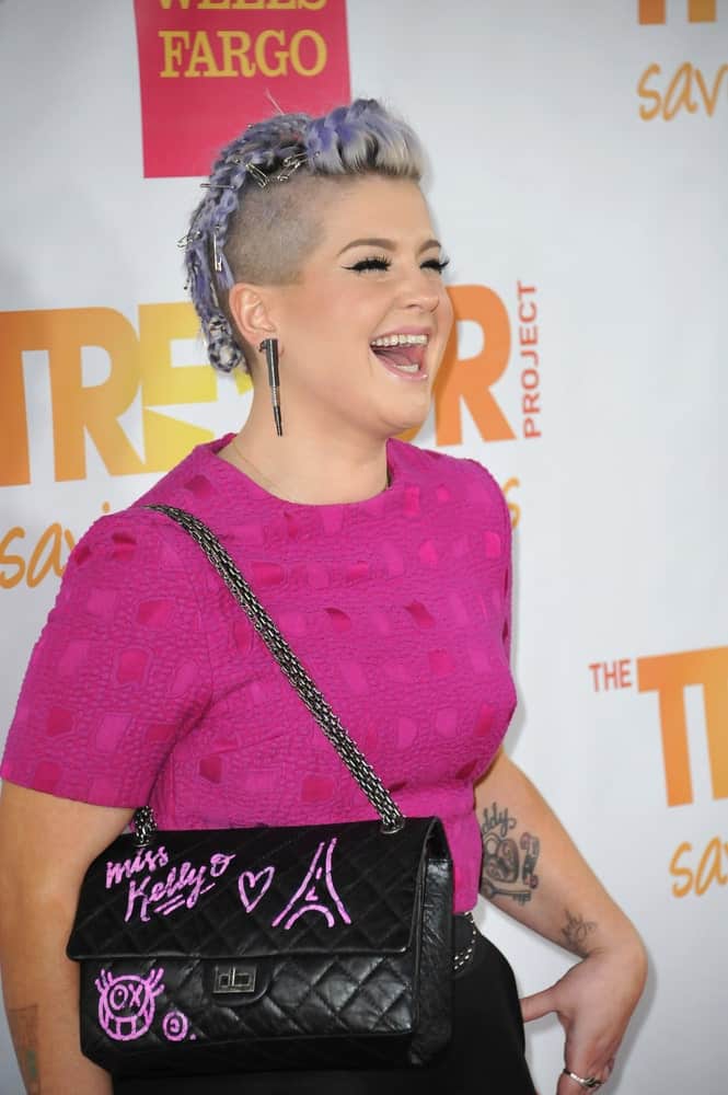 A bold look by Kelly Osbourne during the 2014 TrevorLIVE Los Angeles Gala at the Hollywood Palladium. She wears a purple T-shirt and a violet hairstyle. Photo taken on the 7th of December.