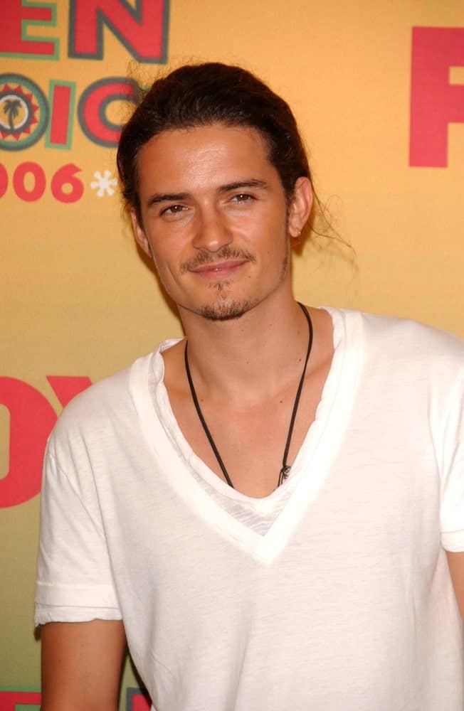 Orlando Bloom was quite the hunk with his simple white shirt and his long hair styled into a man-bun at the 2006 Teen Choice Awards - Press Room at Gibson Amphitheatre on August 20, 2006 in Universal City.