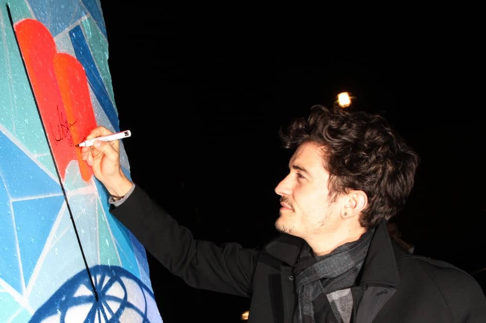 Orlando Bloom signed a piece of the former Berlin Wall at the Cinema For Peace Green Evening on November 12, 2010 in Berlin, Germany. He looked quite dreamy in his messy curls with a slight side-parted style.