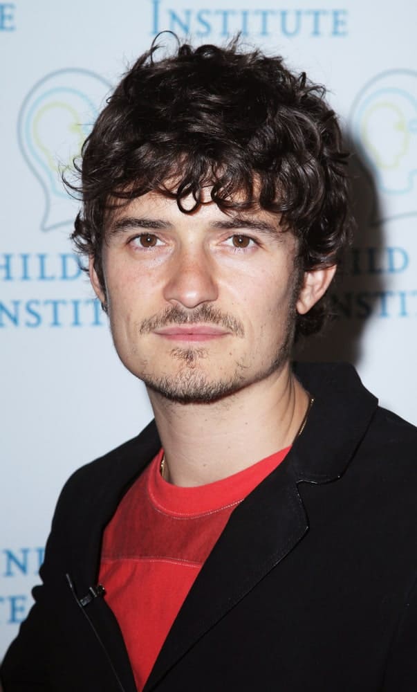 Orlando Bloom spoke at the 2010 Adam Jeffrey Katz Memorial Series Lecture Series at the Rockefeller University on June 2, 2010 in New York City. He wore a smart casual outfit with a  messy long curly fringe hairstyle and trimmed beard.