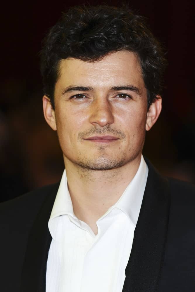 The ever dapper Orlando Bloom wore a classy suit with his short and curly hair with a wet look finish for the UK Premiere of The Three Musketeers, at Westfield, London on October 4, 2011.