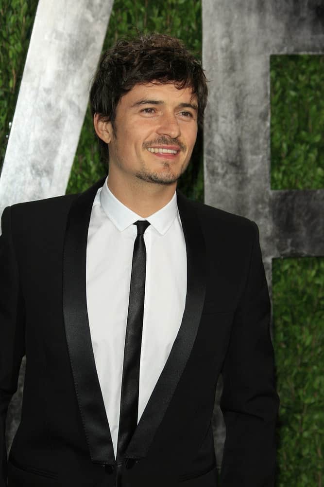 Orlando Bloom's short hair was styled into this gorgeous messy fringe hairstyle that works well with his trimmed facial hair at the Vanity Fair Oscar Party at Sunset Tower on February 24, 2013 in West Hollywood, California.