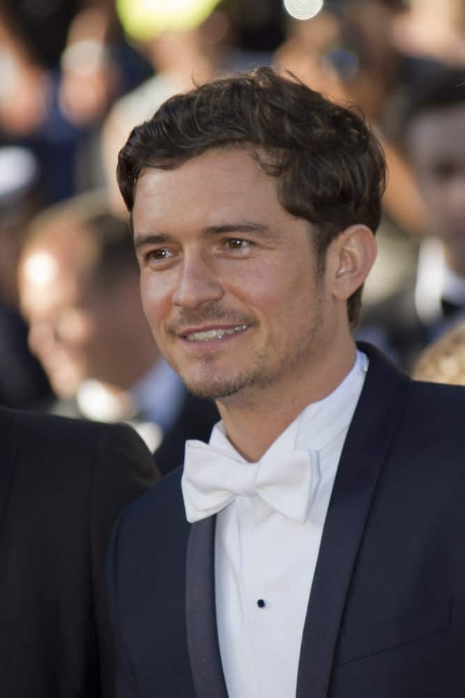 Orlando Bloom attended the Premiere of 'Zulu' and the Closing Ceremony of The 66th Cannes Film Festival at Palais on May 26, 2013 in Cannes, France. He paired his classy suit with a short side-parted curly hairstyle and five o'clock shadow.