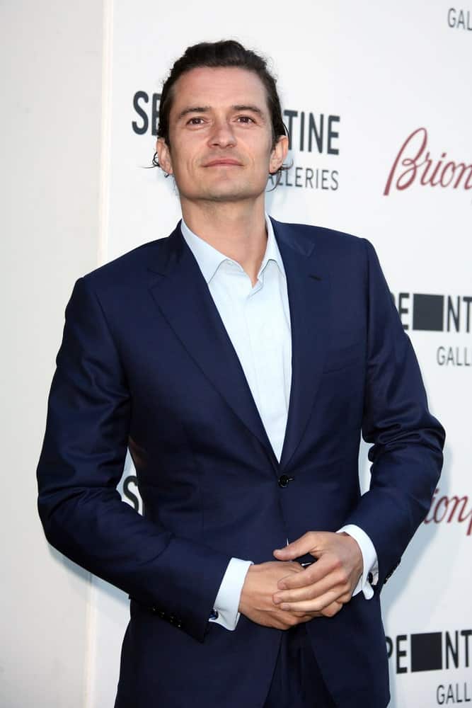 Orlando Bloom swept his long curly hair for a neat man bun hairstyle when he attended the annual Serpentine Galley Summer Party at The Serpentine Gallery on July 1, 2014 in London, England.
