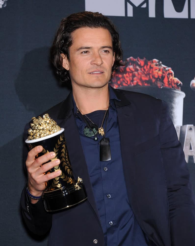 Orlando Bloom's smart casual outfit was a nice complement to his long dark brushed back hairstyle at the 2014 MTV Movie Awards - Press Room on April 13, 2014 in Los Angeles, CA.