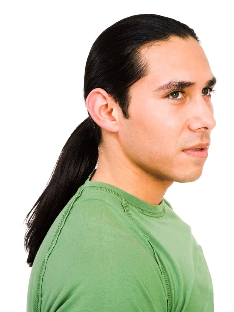 A young man in green T-shirt. He has a long black hair in ponytail style.