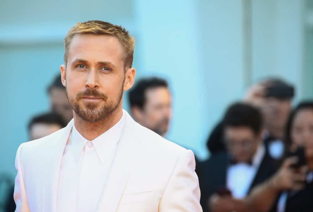 Ryan Gosling walked the red carpet of the ‘First Man’ screening during the 75th Venice Film Festival on August 29, 2018 in Venice, Italy. He wore an all-white suit with his short sandy blond hair in a side-parted crew cut fade hairstyle.