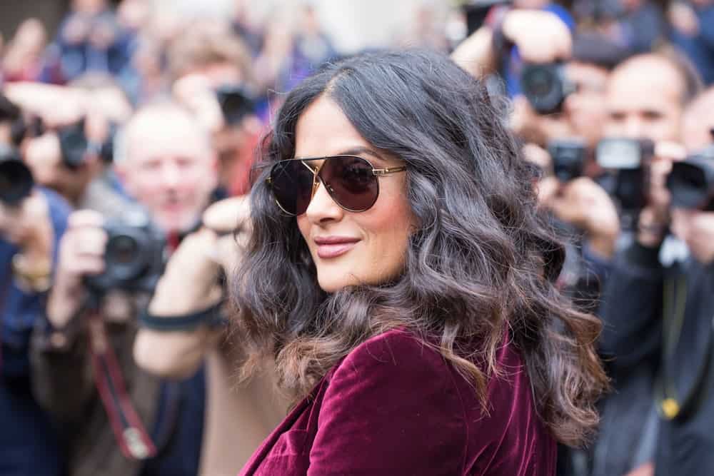 The actress Salma Hayek was at the Stella McCartney fashion show in Paris last October 2, 2017. She was seen wearing a red velvet outfit, a confident smile and tousled wavy hair with highlights.