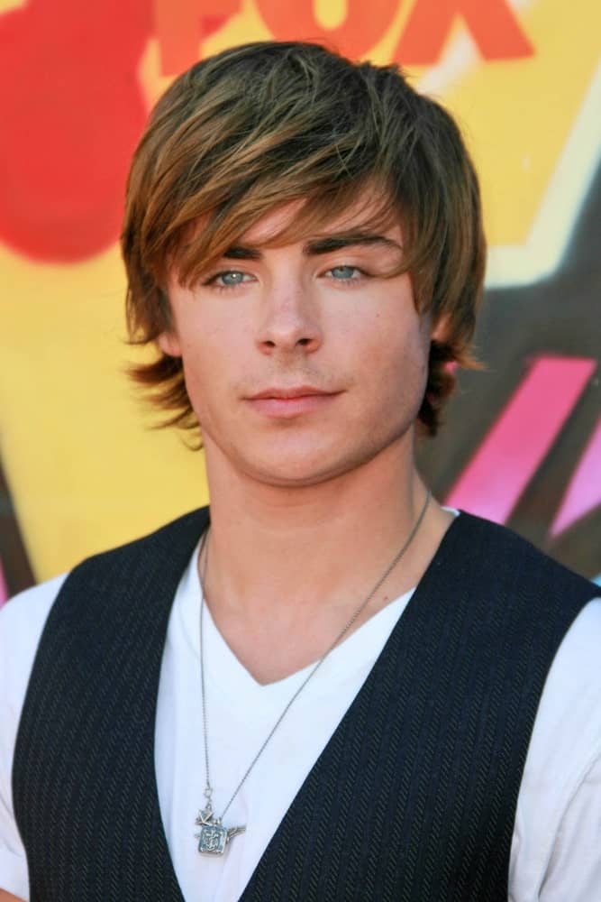 Zac Efron during the 2007 Teen Choice Awards, sporting a side-swept bangs hairstyle along with a white shirt and a vest.