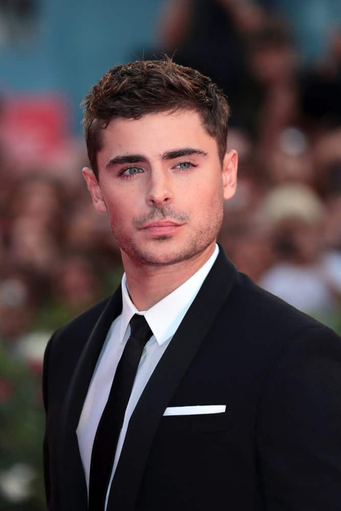 Zac Efron in a classic black suit with a stylish hairstyle, seen at the Venice Film Festival on August 31, 2012.