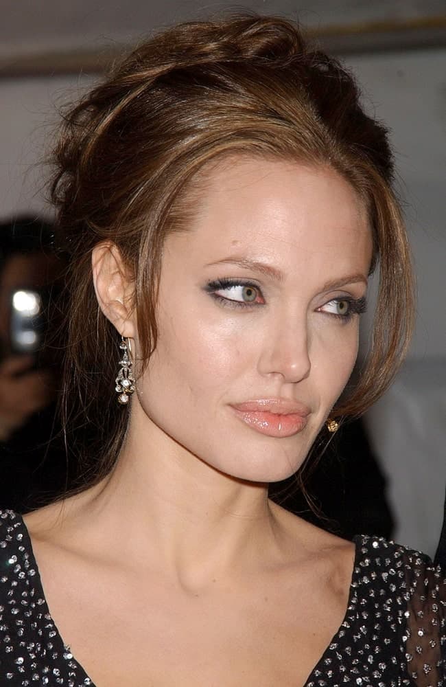 Angelina Jolie’s lovely black bejeweled dress paired quite well with her loose and messy upstyle hair with tendrils and bangs at the Premiere of THE GOOD SHEPHERD in Ziegfeld Theatre, New York on December 11, 2006.