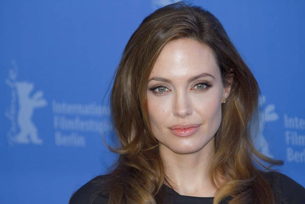 Angelina Jolie attended the ‘In The Land Of Blood And Honey’ Photocall during of the 62nd Berlin Film Festival at the Grand Hyatt on February 11, 2012, in Berlin, Germany. She wore simple make-up to match her black outfit and loose tousled brunette hairstyle with layers and curls.