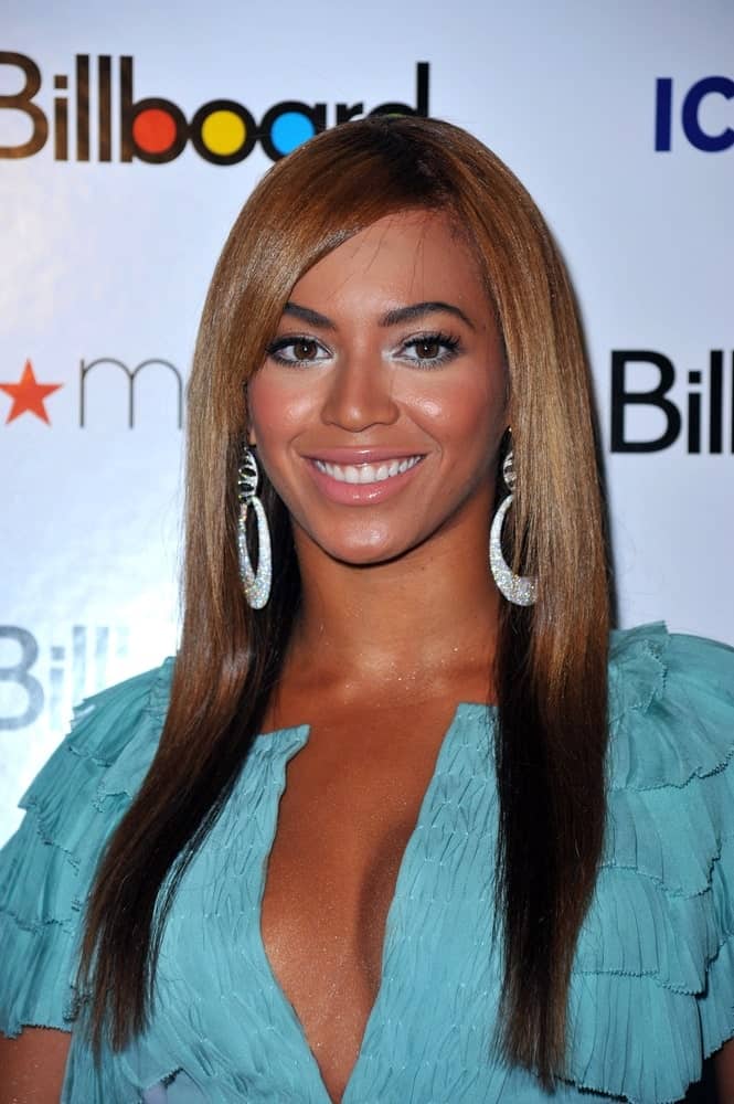 On October 2, 2009, Beyonce Knowles wore a blue ruffled dress along with a sleek straight side-parted hairstyle at Billboard’s Women in Music Brunch, The Pierre Hotel, New York, NY.