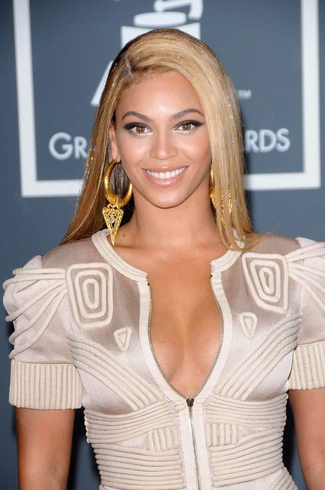 Beyonce Knowles looking sleek in a blonde straight hairstyle with a deep side part at the 52nd Annual Grammy Awards on January 31, 2010. She finished the look with a textured geometric dress and gold statement earrings.