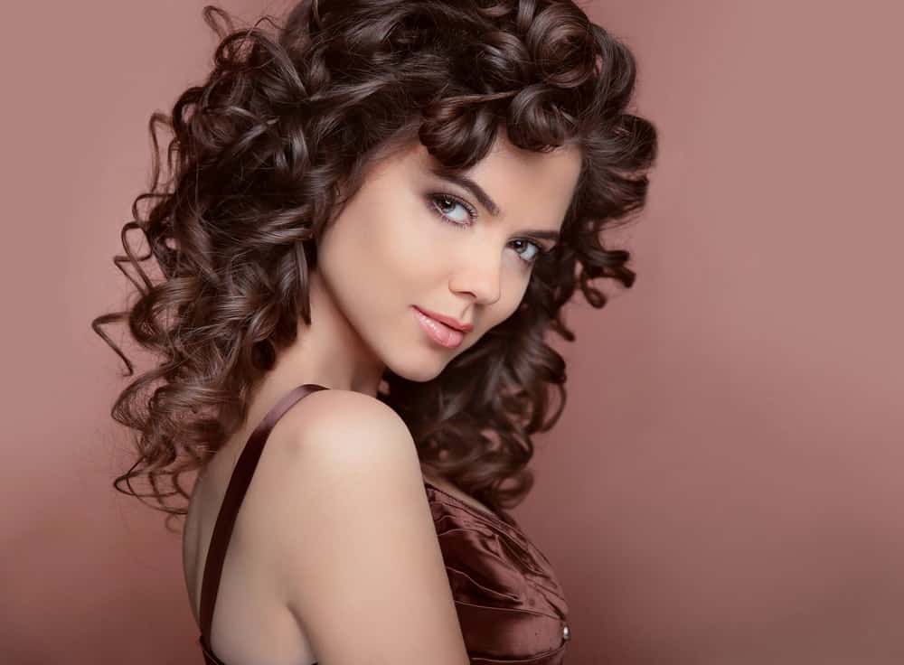 A pretty brunette woman with long curly hair.