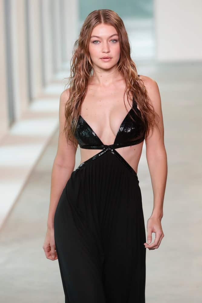 Gigi Hadid’s hair was styled into a wet-look tousled and wavy loose hairstyle when she walked the runway wearing Michael Kors Spring 2019 on September 12, 2018, in New York City.