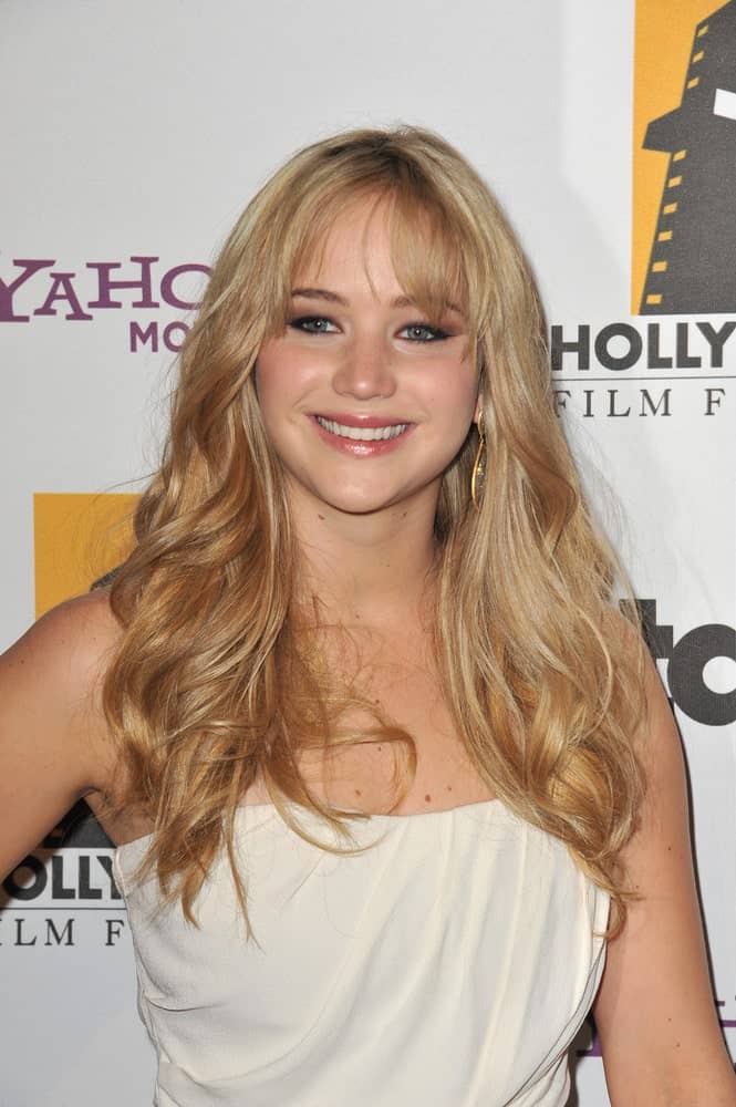 Jennifer Lawrence’s long, layered and highlighted sandy blond hair was complemented with wispy bangs and a white strapless dress at the 14th Annual Hollywood Awards Gala at the Beverly Hilton Hotel on October 25, 2010, in Beverly Hills, CA.