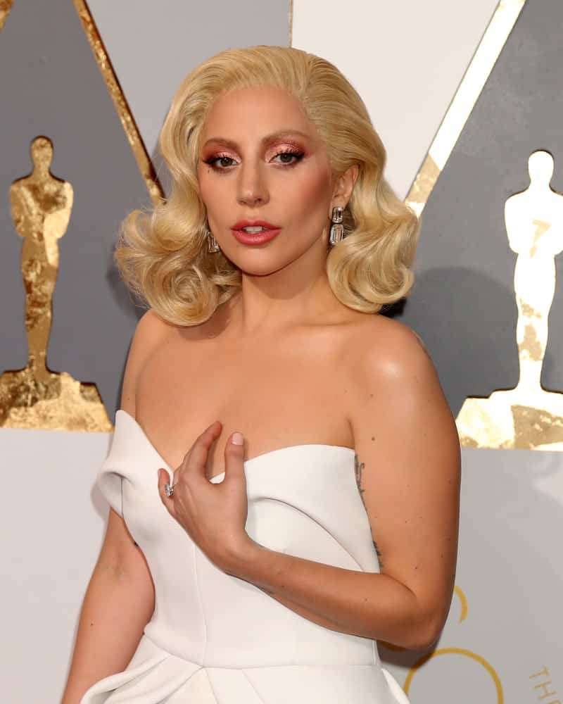 Lady Gaga attended the 88th Annual Academy Awards at the Dolby Theater on February 28, 2016, in Los Angeles, CA. She paired her lovely white strapless dress with a vintage look on her white-blond hair that was styled into side-swept large curls.