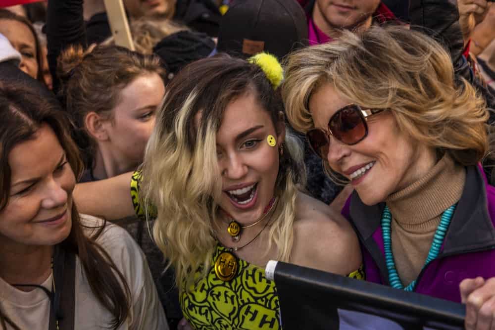 On January 21, 2017, Miley Cyrus and Jane Fonda participated in the Women’s March, 750,000 activists protesting Donald J. Trump the day after Presidential Inaugural in Los Angeles. Miley went with a yellow dress to go with her side-swept tousled balayage hairstyle.