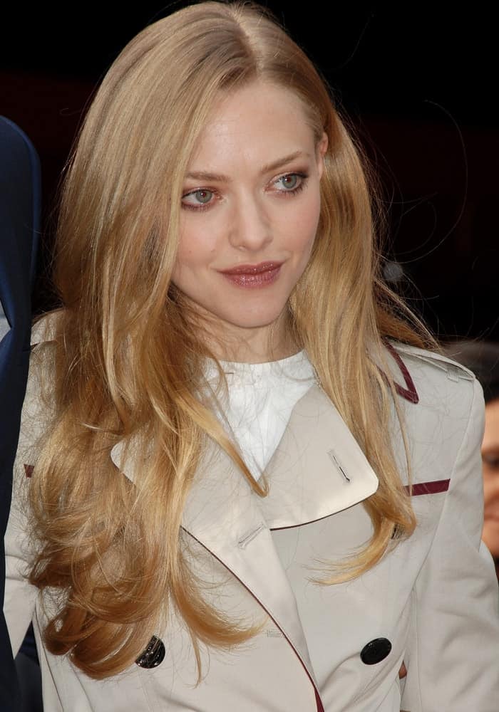 Amanda Seyfried was in attendance at the Hugh Jackman Star On The Hollywood Walk Of Fame Ceremony on December 13, 2012, in Los Angeles, CA. She wore a trench coat that she paired with her loose and tousled sandy blond hairstyle with subtle layers and highlights.