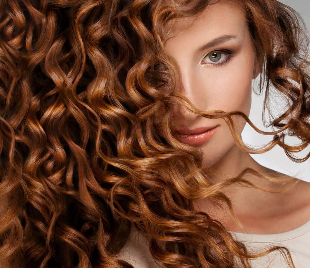Woman with thick curly auburn hair.