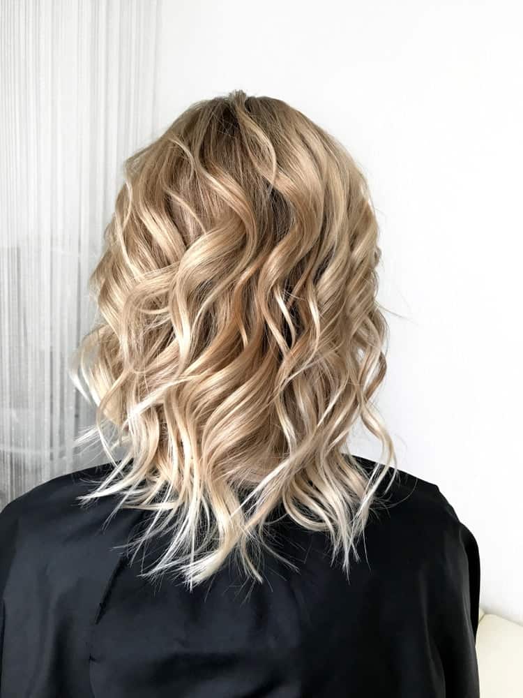 A woman with short blond hair that has lots of waves.
