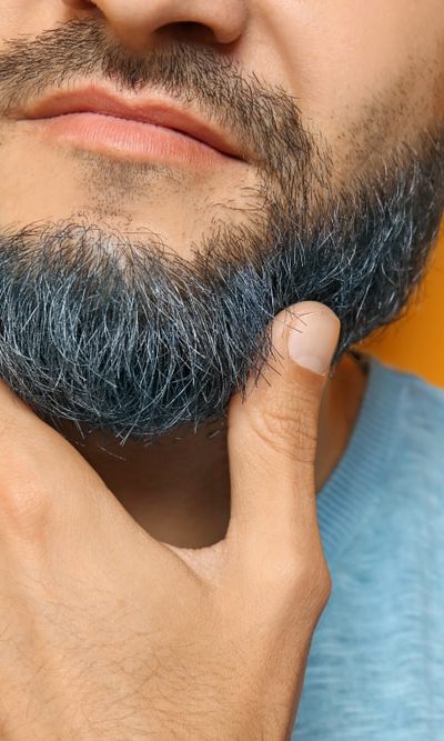 A close look at a man with a dyed beard.