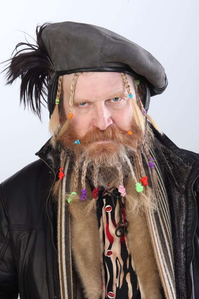 Man with long beard braided in pigtails.
