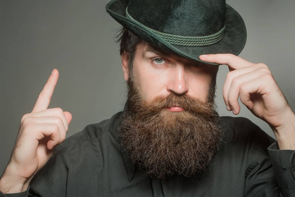 Man with long beard and mustache in a stylish black retro hat.