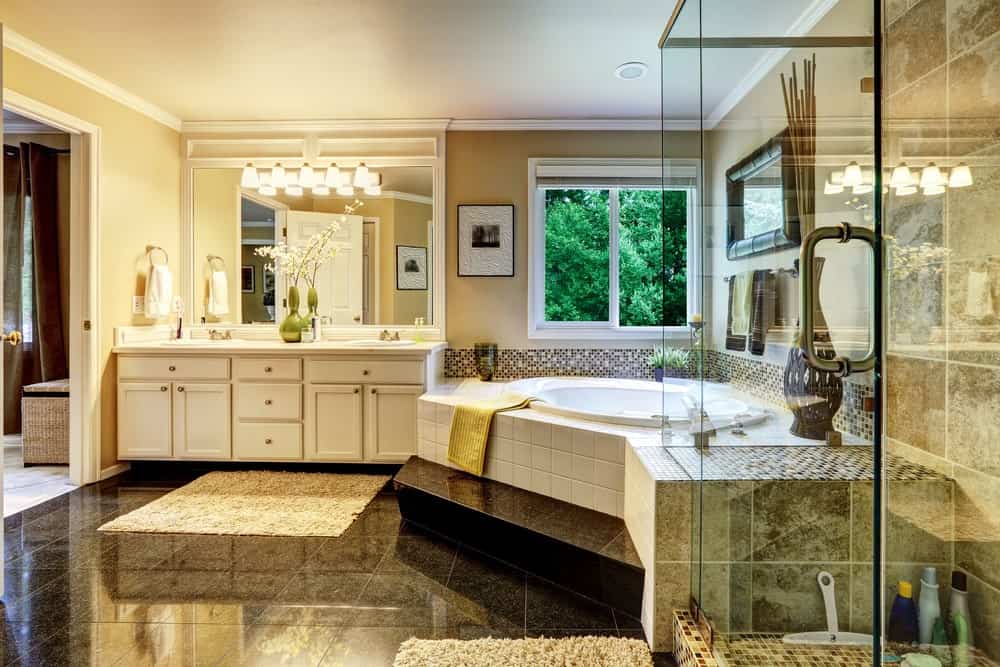 Luxury bathroom interior with walk-in shower, corner tub, and a white vanity.