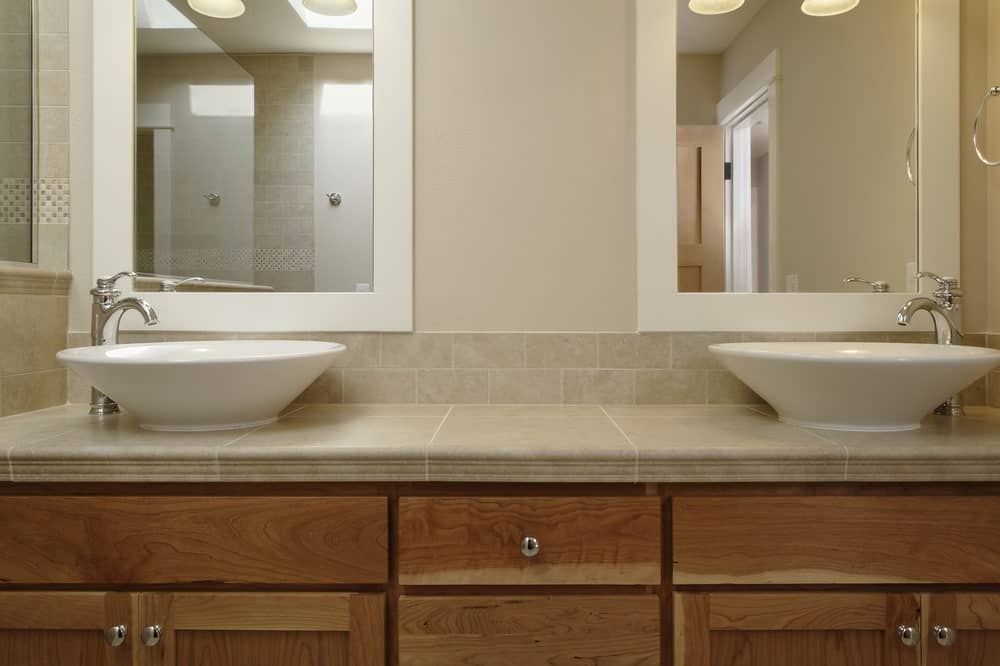 Wooden vanity with his and her vessel sinks.