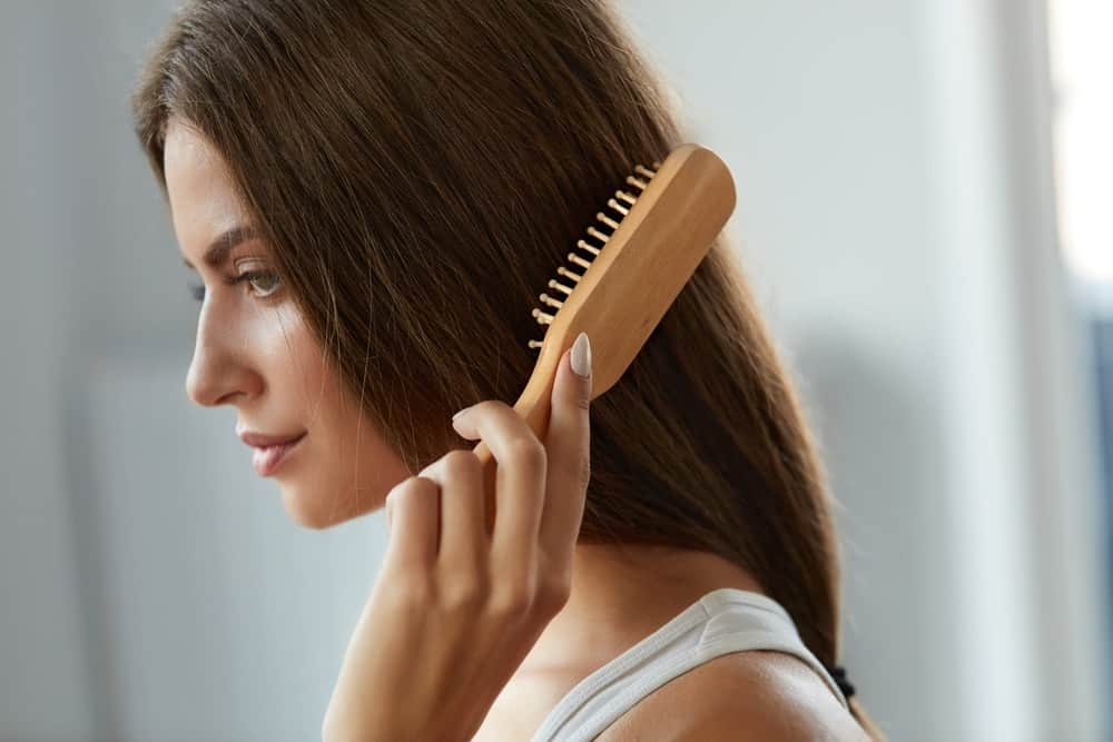 A woman brushing her long brown hair.