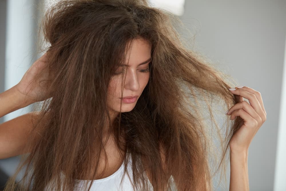A woman with long, frizzy and damaged hair.