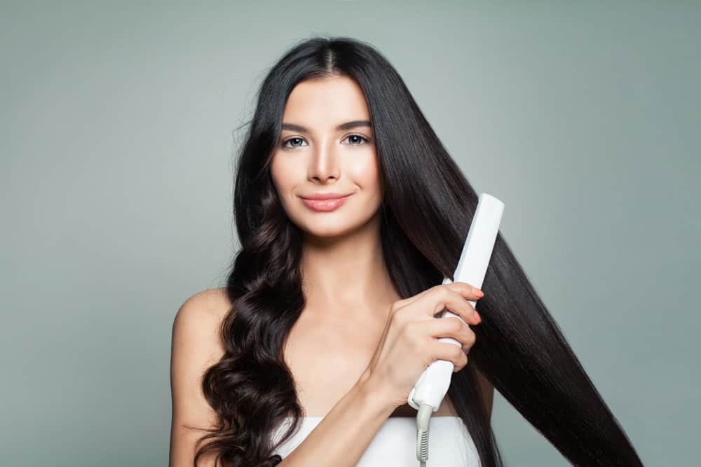 A woman ironing her long dark hair.